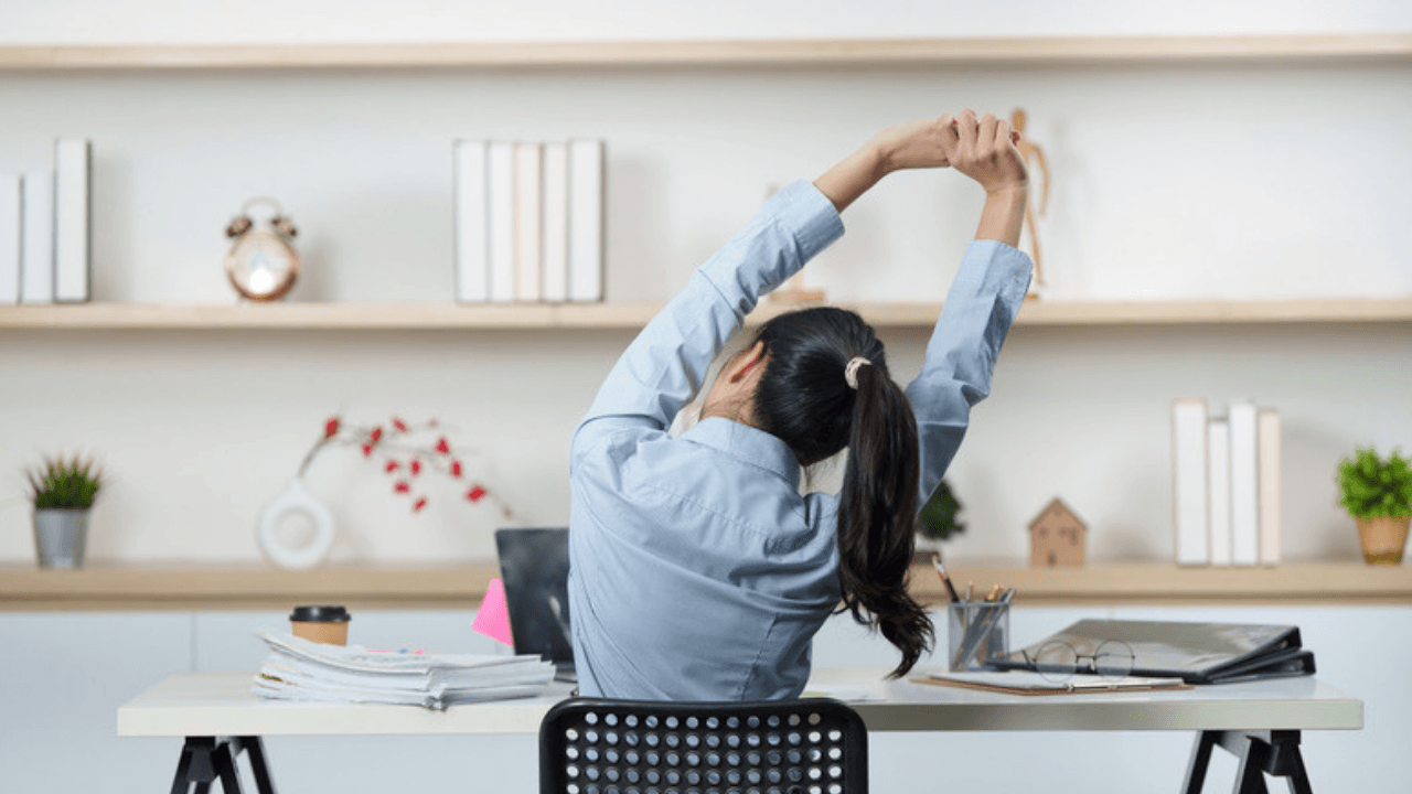 Person stretchar vid skrivbord