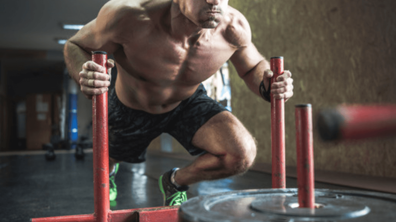 Man pushar lastad träningssläde i gym – sled push