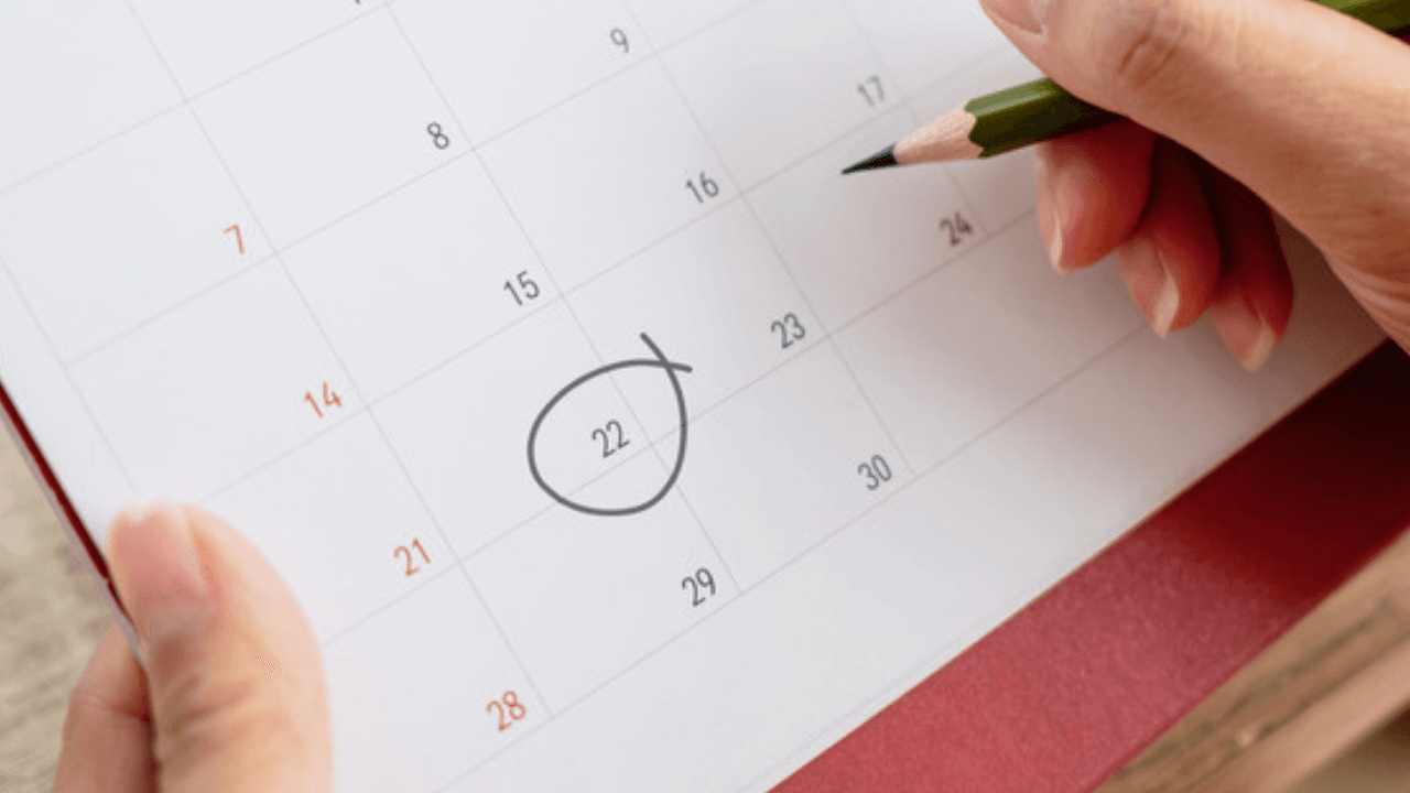 Hand ringar in datum i kalender med penna