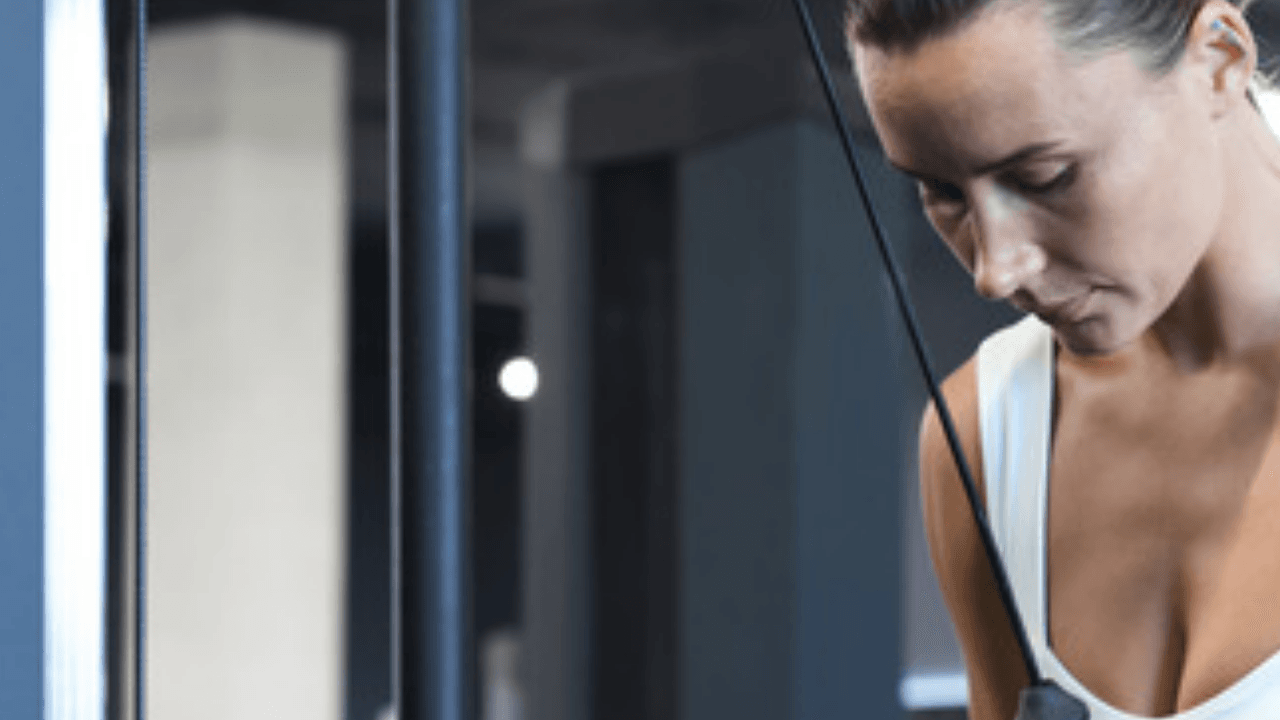 Person tränar vid kabelmaskin i gym – alternativ för front raise